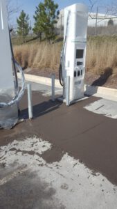 Black concrete with bollards at an electrical station