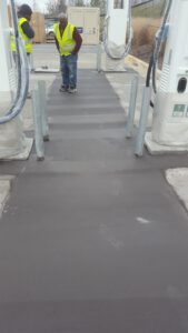 Black concrete with bollards at an electrical station