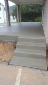 Steps and poured patio on the side of a residential building