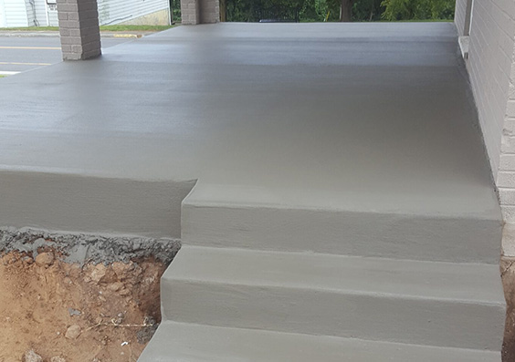 Steps and poured patio on the side of a residential building