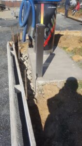 Poured concrete equipment pad with bollard and curved curb forms