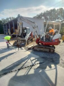 Crew breaking up old concrete apron before replacement