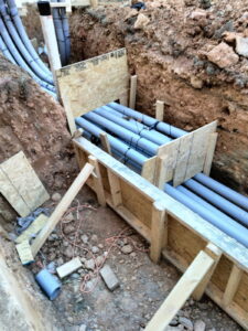 Conduit stub-ups braced in position along a building wall.