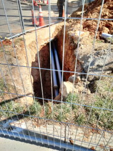 Underground conduit in place within a secured work zone.