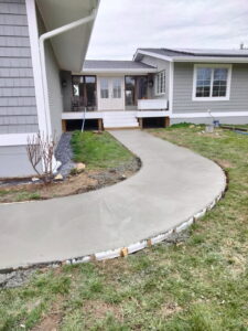 A new curved concrete walkway to the front entry.