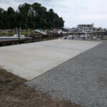 A new concrete pad poured next to the water.