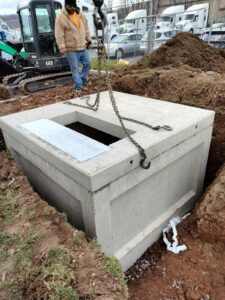 Setting a precast concrete vault into the excavation.